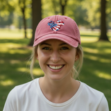 Woman wearing a pink cap with an American flag design in a park setting